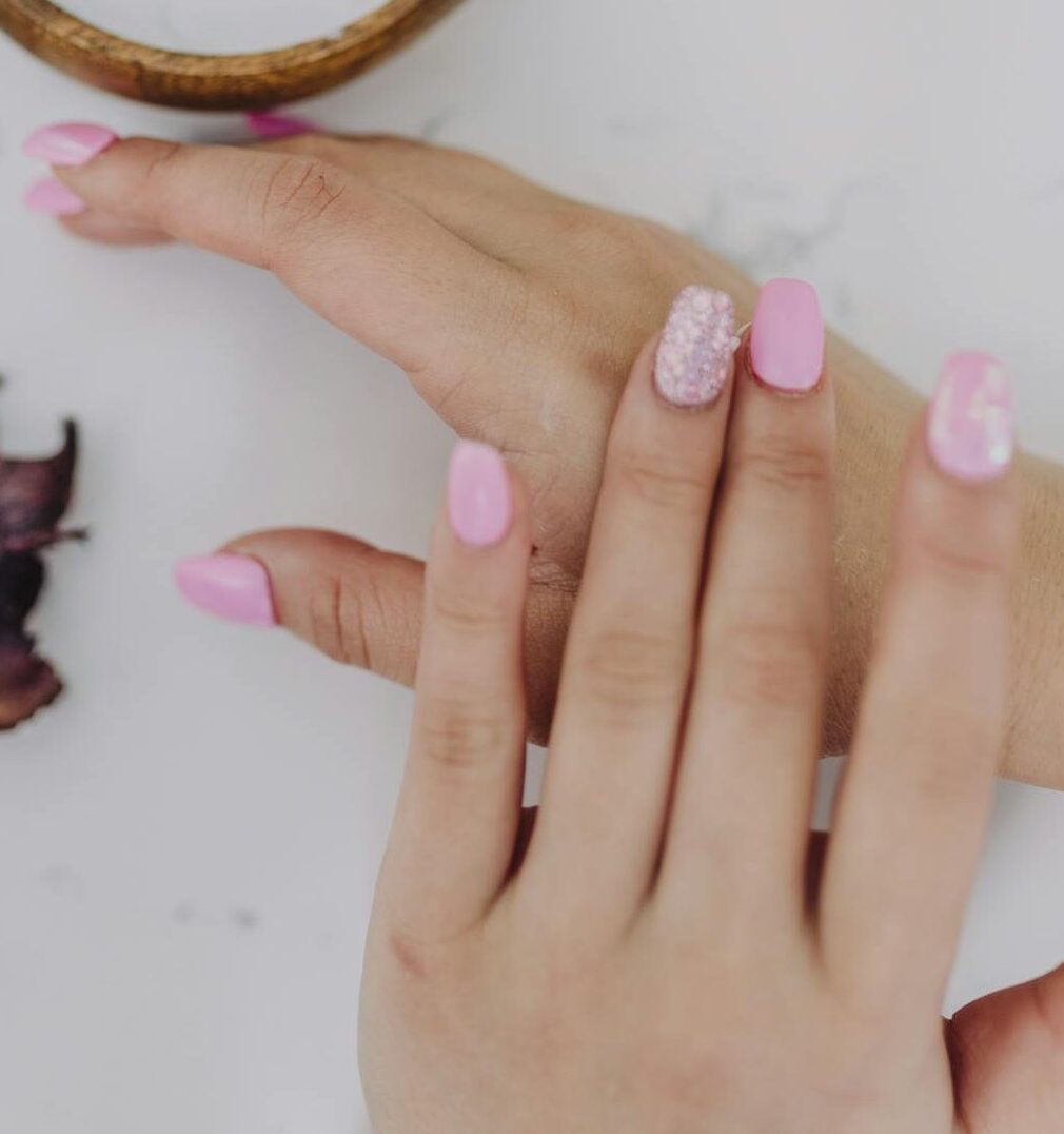 Beautiful pink manicure and spa products create a calming and luxurious experience.